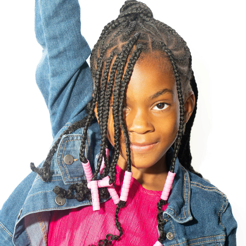 child with long braided hair wearing pink Bead Barrettes
